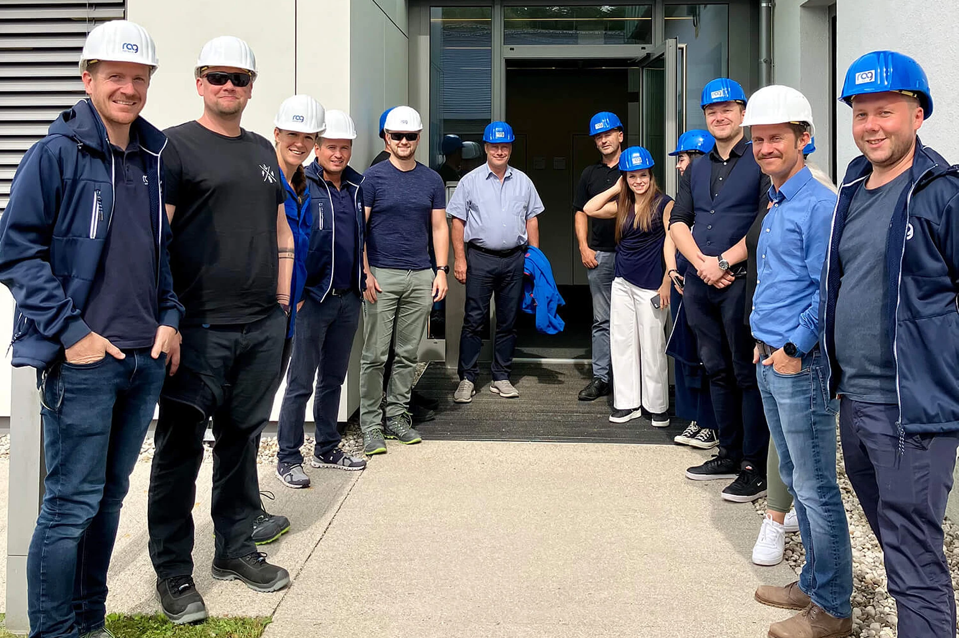 RAG employees wearing helmets at the Welcome Days in front of the office building