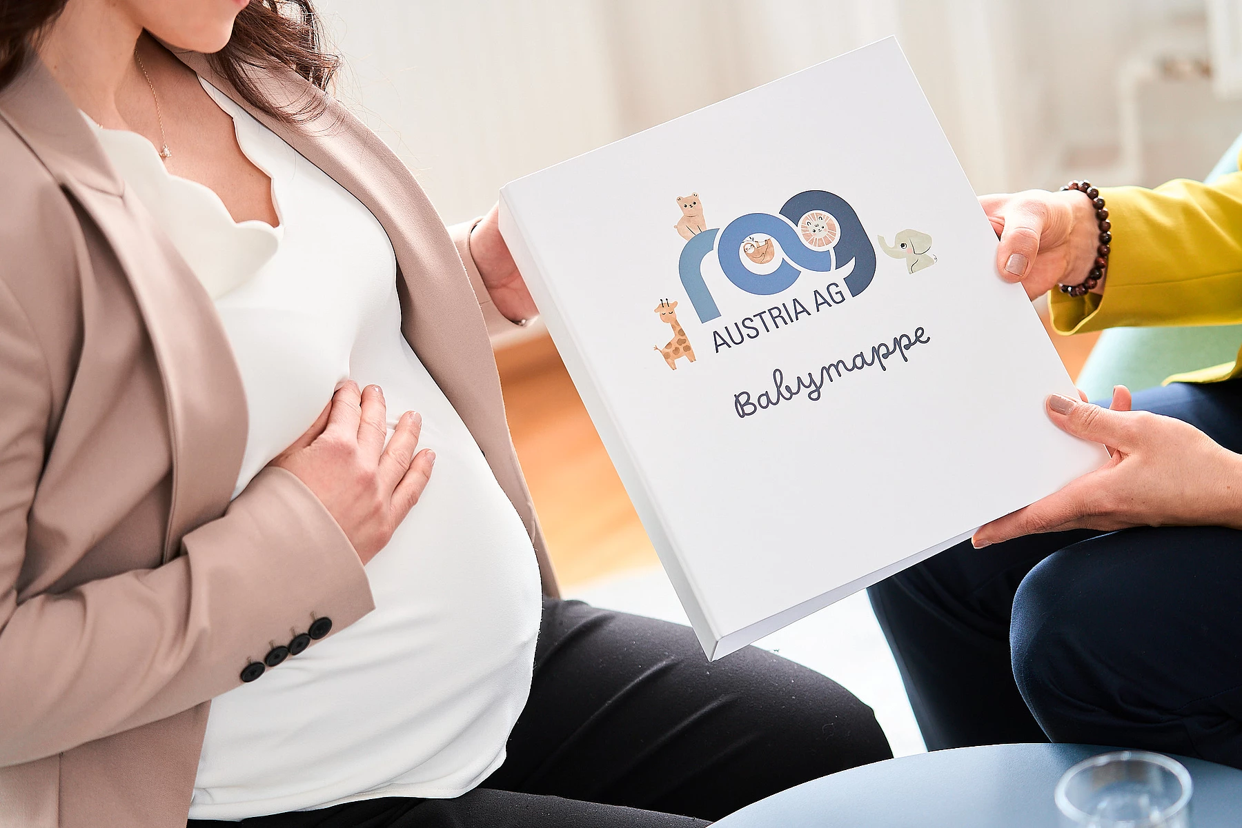 Kollegin bekommt RAG Babymappe überreicht.