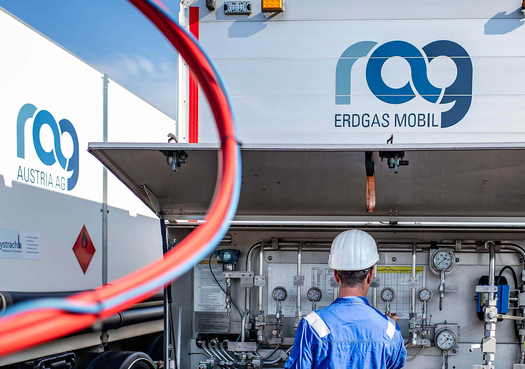 RAG Mitarbeiter vor einer Betriebsanlage mit RAG Logo