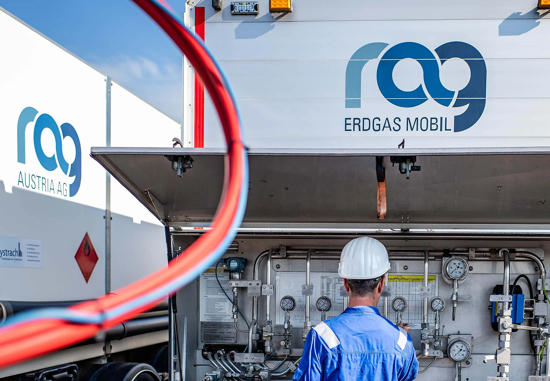 RAG employees in front of a plant with the RAG logo