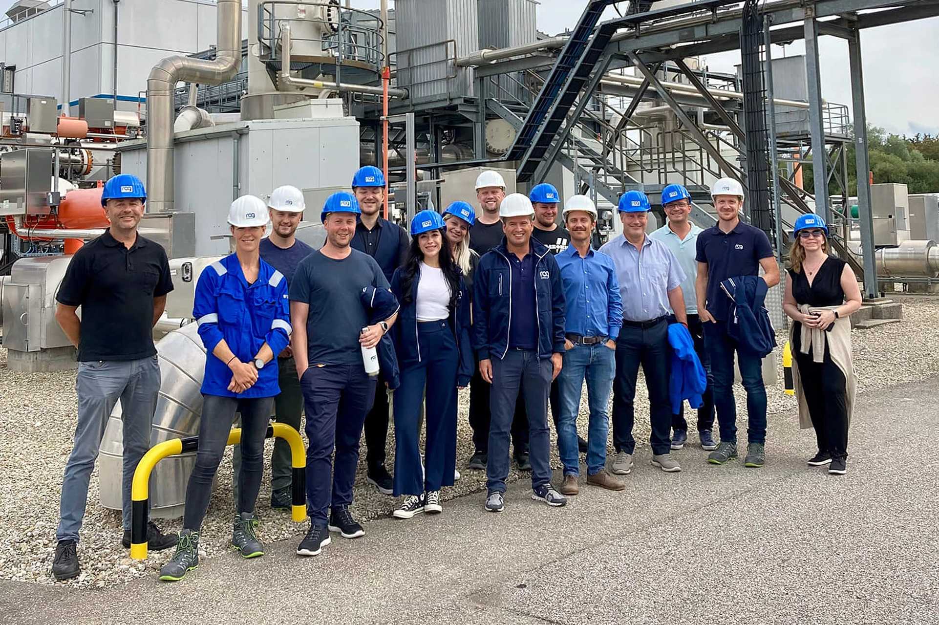 RAG employees wearing helmets at the Welcome Days in front of a plant